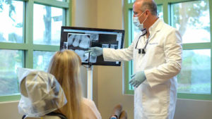 Dr. James Annicchiarico showing a patient an x-ray of her teeth