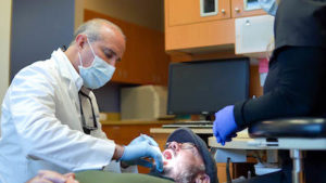 Dr. Annicchiarico checking a new dental crown inside of a patient's mouth