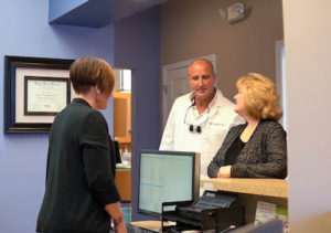 Dr. James Annicchiarico and a patient discussing a next appointment with the office coordinator at A Glamorous Smile