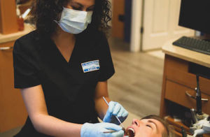 hygienist cleaning a patient's teeth at A Glamorous Smile